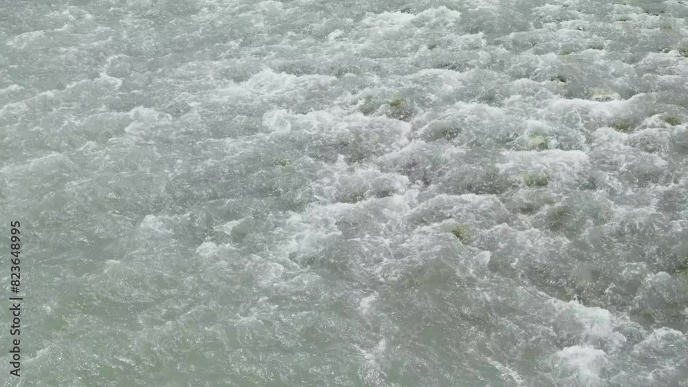 rapid flow of water among rocks in mountain river close-up, slow motion

