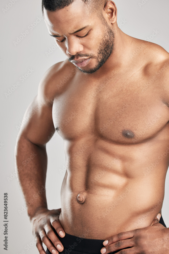 Male bodybuilder, topless and muscle in studio for wellness, healthy body and six pack on gray background. Black man, fitness and performance or strength for health with masculine and confidence Male bodybuilder, topless and muscle in studio for wellness, healthy body and six pack on gray background. Black man, fitness and performance or strength for health with masculine and confidence