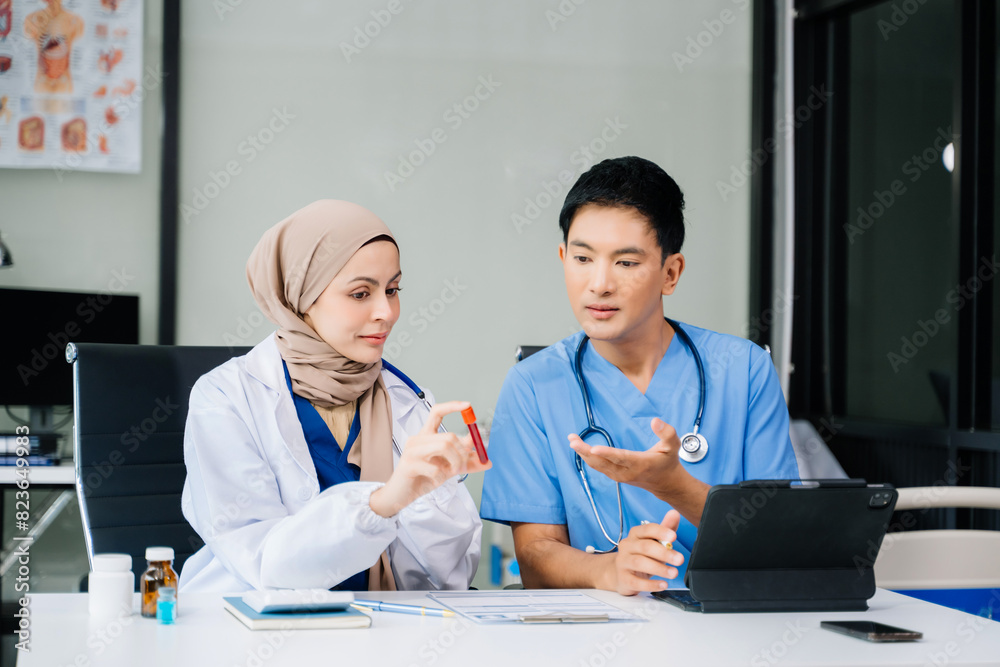 Doctor Talks With Professional Head Nurse or Surgeon, They Use Digital tablet Computer. Diverse Team of Health Care Specialists Discussing Test Result on desk Doctor Talks With Professional Head Nurse or Surgeon, They Use Digital tablet Computer. Diverse Team of Health Care Specialists Discussing Test Result on desk