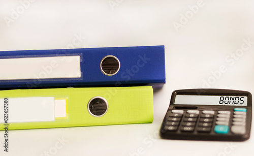 Calculator with the word Bonds, folders on a white background