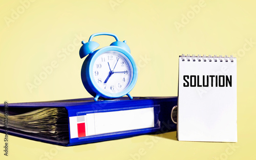 The word solution written on a notepad on a yellow background