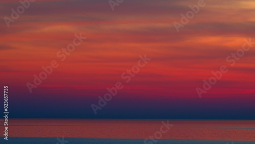Purple Or Pink And Violet Sunset Over Sea Horizon. Sun Slowly Sets Over Calm Waters. Nature Composition.