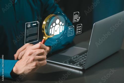 Human resource manager hand holding magnifying glass search with human icons, HRM, CRM, recruitment consulting and human resource management.