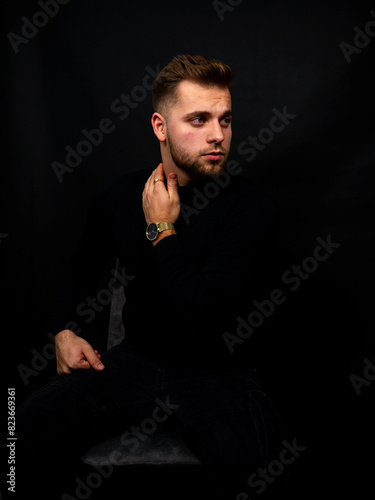 Młody poważny mężczyzna na sesji zdjęciowej w studio