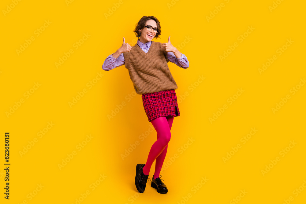 Photo portrait of attractive young woman show thumb up dressed retro office clothes isolated on yellow color background Photo portrait of attractive young woman show thumb up dressed retro office clothes isolated on yellow color background