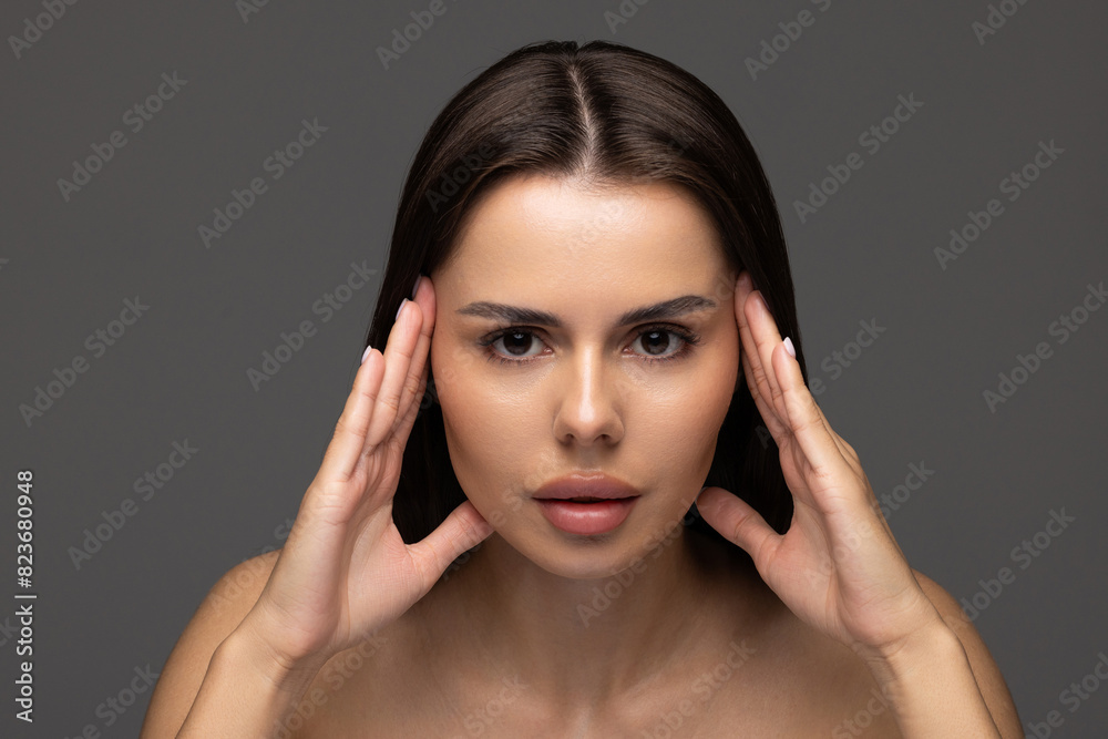 Portrait of woman with natural nude make up with bare shoulders on gray background. Portrait of woman with natural nude make up with bare shoulders on gray background.