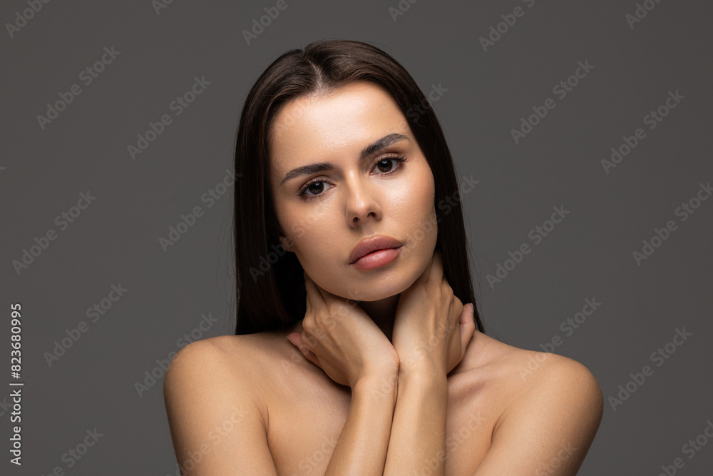 Portrait of a young woman with natural make up on gray background