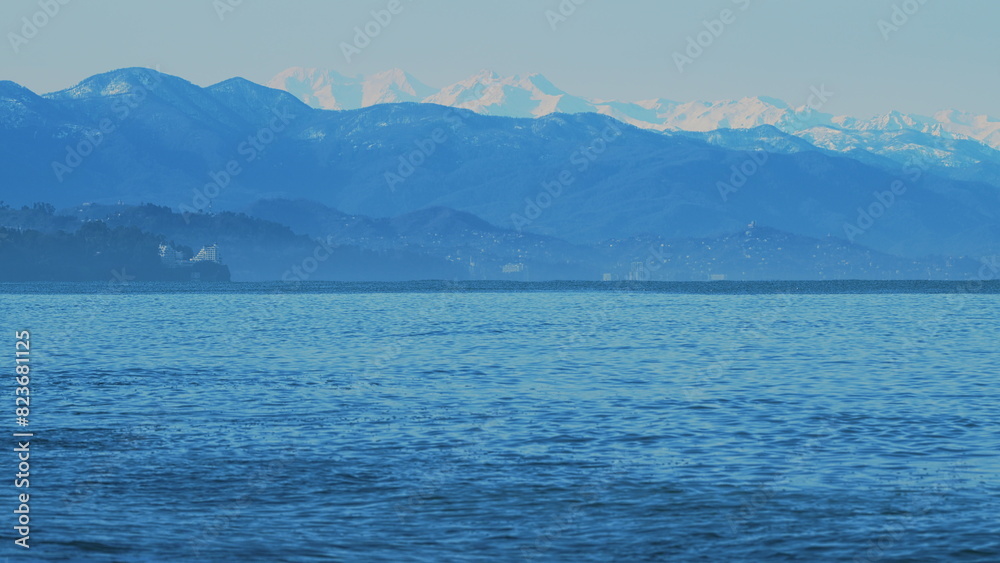 Wavy Black Sea Between Snowy Mountains. Sea By Snow Covered Mountains.