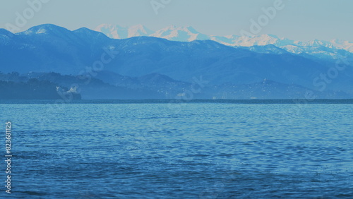 Wavy Black Sea Between Snowy Mountains. Sea By Snow Covered Mountains.