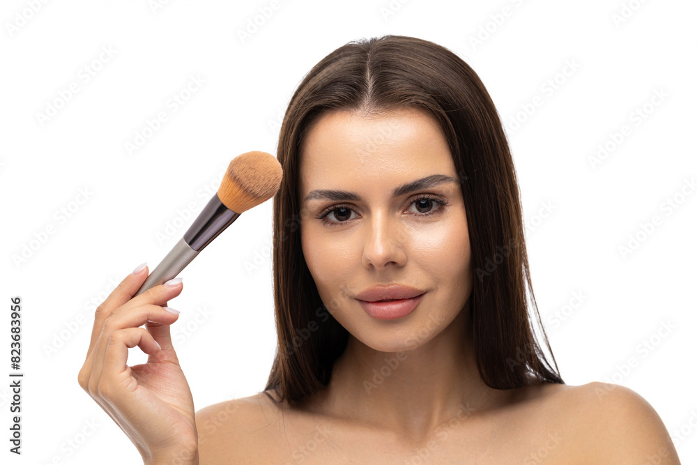 Portrait of an excited beautiful half naked woman holding set of make-up brushes and winking on white background Portrait of an excited beautiful half naked woman holding set of make-up brushes and winking on white background
