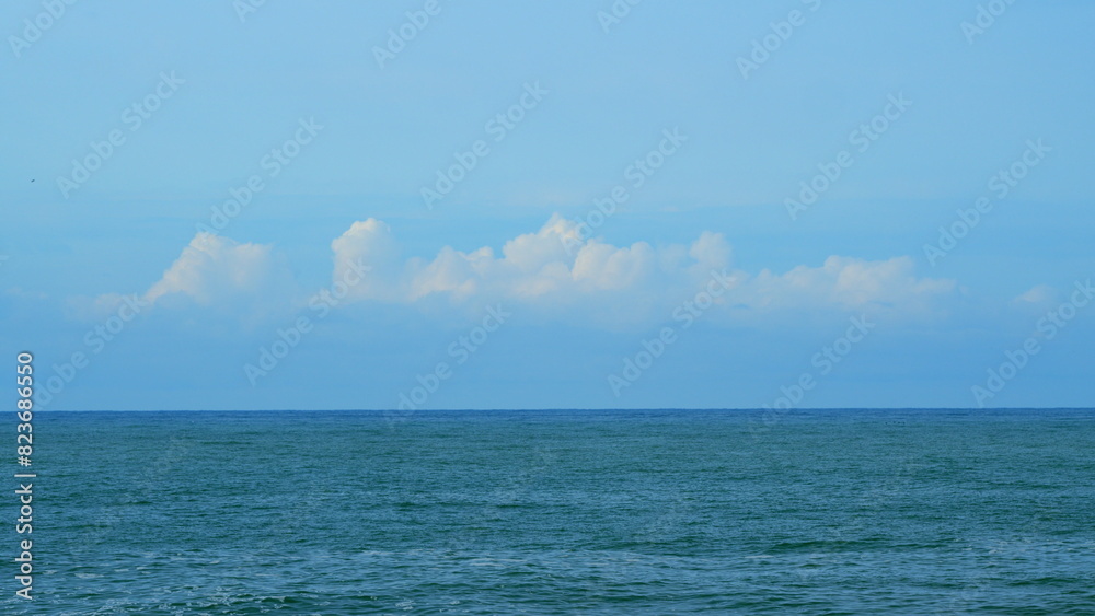 Quiet Seascape. Calming Waves Of The Sea Or Ocean During A Warm Sunny Day With A Blue Sky With Clouds. Still.
