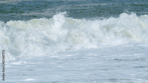 Foam Blue And Green Waves On Gray Sand. Choppy Sea Captured With Telephoto Lens. Rough Sea With Storm. Slow motion.