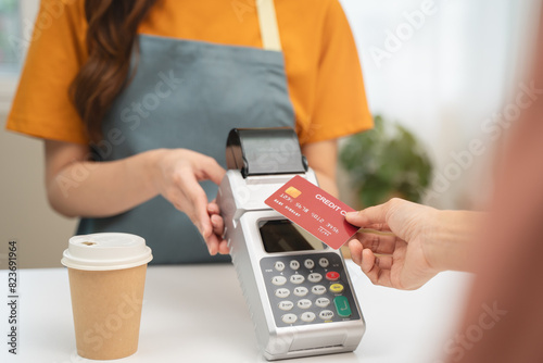 Cashless payment in shopping concept, Close-up hands using credit card pay at cafe.