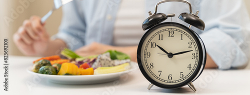 Obraz na płótnie Intermittent fasting concept, Close-up on clock and people feeling hungry waiting time to eat during intermittent fasting diet session