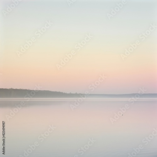 A calm lake with a beautiful pink and orange sky in the background