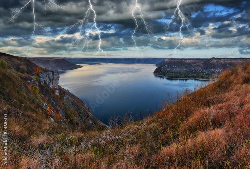 Peaceful view of the canyon Dnister river in a storm. Dramatic landscape with thunderstorm. Powerful lightning over the river. Nature of Ukraine