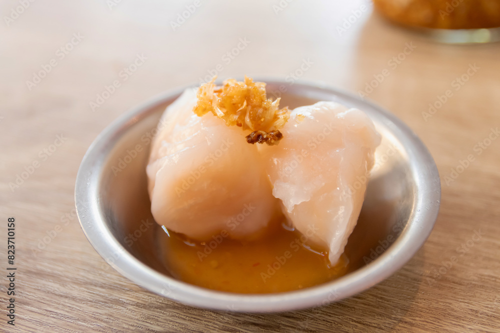 Steamed shrimp dumpling with sweet and sour sauce in a metal bowl on a wooden table. Steamed shrimp dumpling with sweet and sour sauce in a metal bowl on a wooden table.