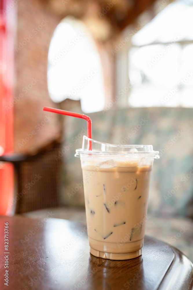 Iced coffee in a plastic cup on a vintage wooden table. Iced coffee in a plastic cup on a vintage wooden table.