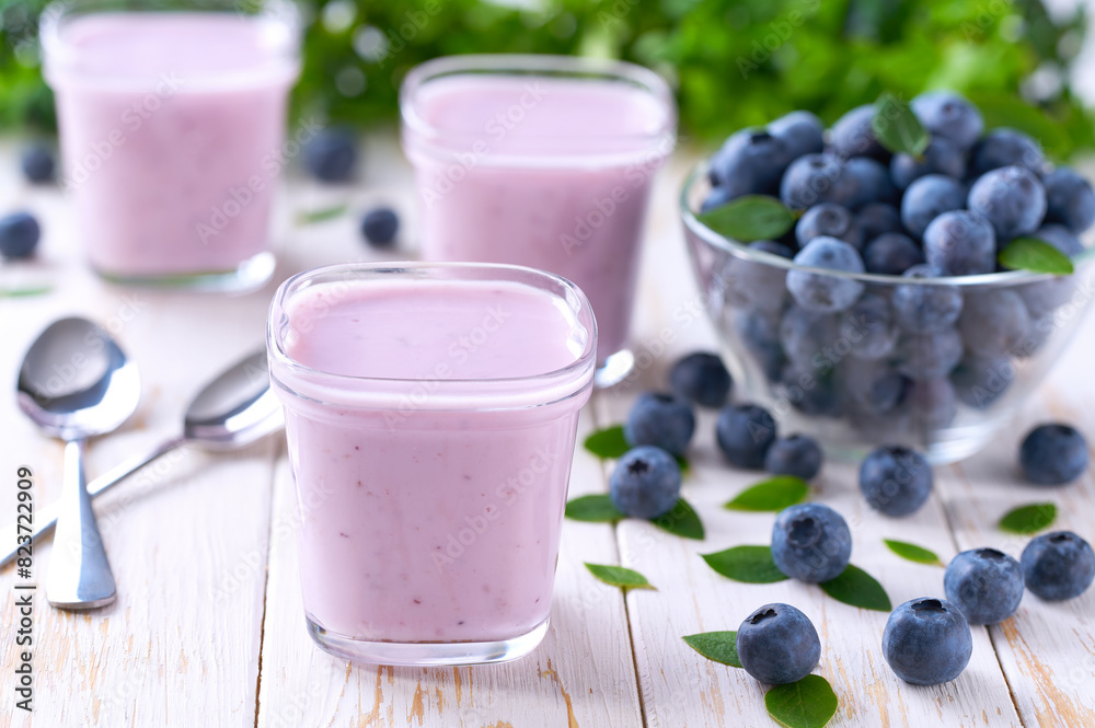 homemade blueberry smoothie in a glass jars with fresh blueberries on a white table, selective focus. homemade blueberry smoothie in a glass jars with fresh blueberries on a white table, selective focus.