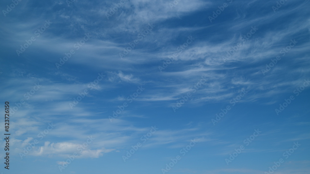 Transparent cloudscape nature background. Beautiful white cirrus clouds moving high over blue sky background. Timelapse.