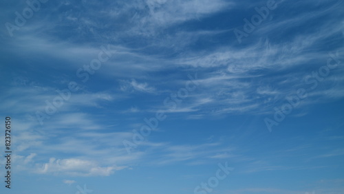 Transparent cloudscape nature background. Beautiful white cirrus clouds moving high over blue sky background. Timelapse.