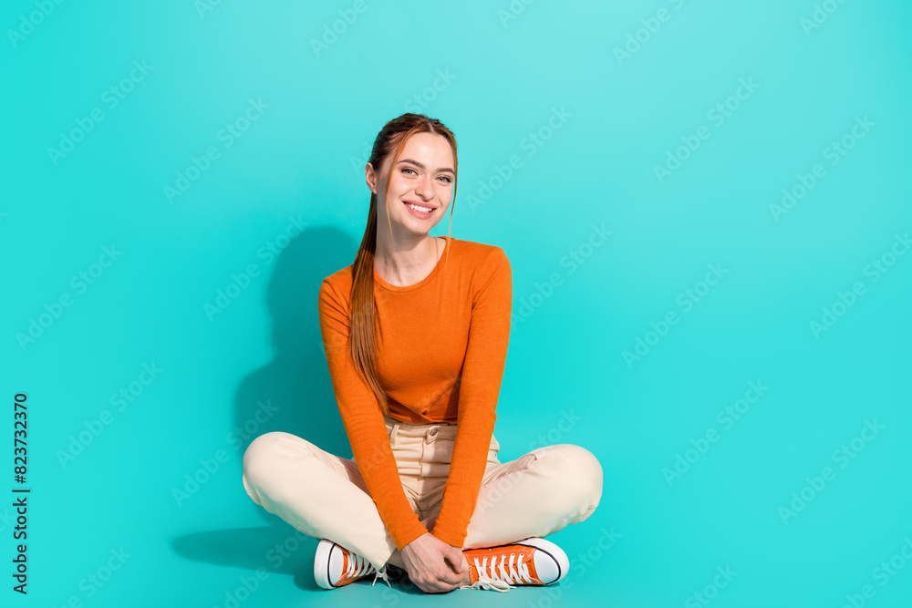 Φωτογραφία Full size photo of positive lovely girl dressed orange shirt white trousers sit