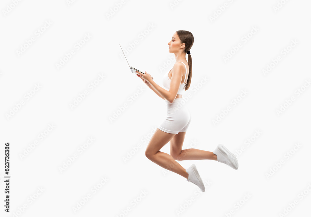 Naklejka premium Slender dark-skinned female blogger in a white tracksuit against a white background. Healthy lifestyle, sports and diet.