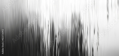Abstract black and white background with vertical blurred lines creating effect of smooth movement. Monochrome grayscale gradient design is perfect for modern minimalist decor or digital art projects