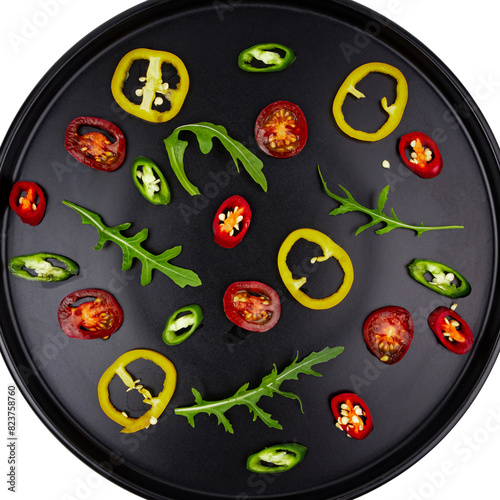 Black plate with sliced vegetables pattern, top view
