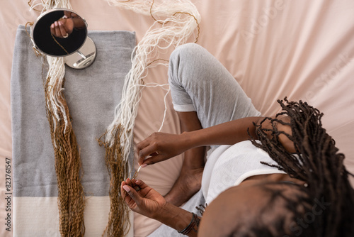 Anonymous woman twisting hair extensions together