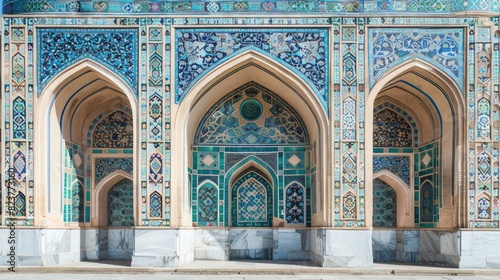 The intricate geometric patterns of the Samarkand Grand mosaic  showcasing blue and green tiles in an archway  set against white walls with decorative tilework.