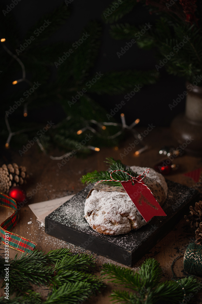 Christmas stollen cake on a wooden box on a rustic background. Traditional handmade German Christmas dessert. Fruit bread Stollen with nuts, raisins and marzipan.