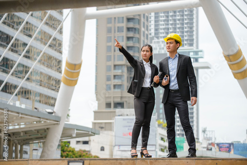 Construction man engineer Manager point and check quality at building project. Business woman consult and plan with civil engineer at construction site.