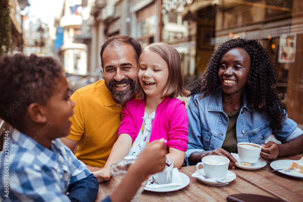 Happy multiethnic family enjoying time at a cafe together Happy multiethnic family enjoying time at a cafe together