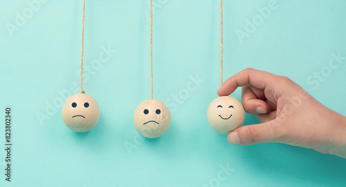 Happy smiling face spread happiness to sad faces, newton cradle concept, mental health and attitude, positive and negative mind, influence emotion, support and depression, pendulum balls