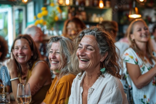 Group of happy senior women having fun in a pub. They are laughing and drinking wine.