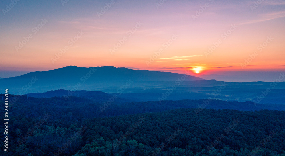 Obraz premium Aerial view of sunrise over mountian and pine tree in Chiang Mai Province, Thailand.