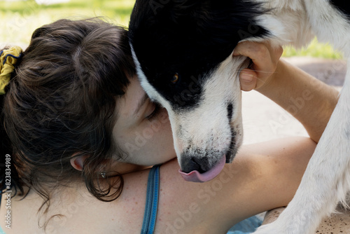 Woman embracing and kissing border collie dog photo