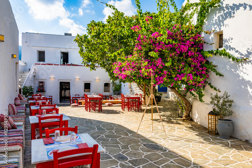 Obraz na płótnie Typical Greek taverna restaurant with red chairs and bougainvillea flowers on square in Apollonia village, Sifnos island, Greece w salonie