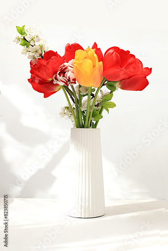 Beautiful spring flowers tulips in a vase on a sunny background, banner. Abstract flower arrangement, still life with space for text, floral holiday card, summer greeting concept,