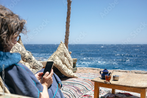Woman turning off mobile phone at vacation photo
