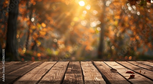 A wooden table with an autumn background. The focus is on the empty tabletop  set against a blurred scene of trees and leaves in fall colors