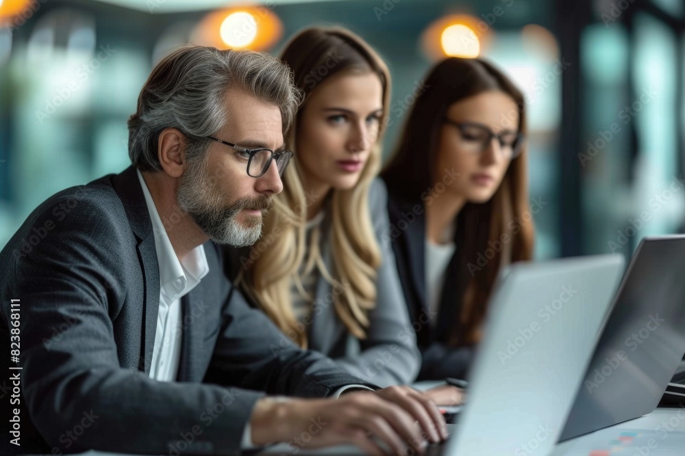 Three business people in the office working together Three business people in the office working together