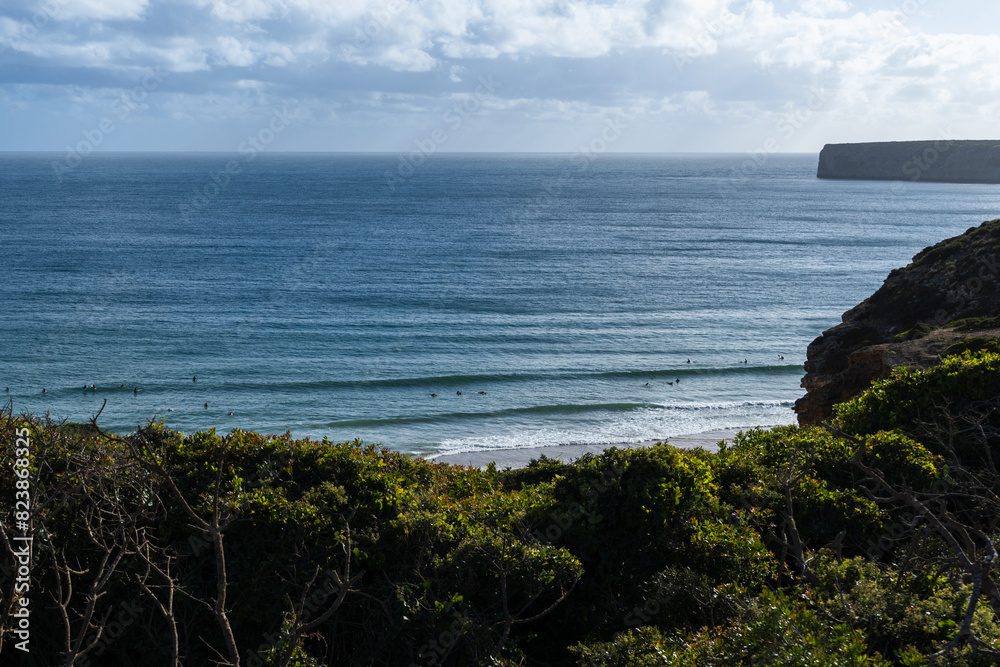 Praia do Beliche beach in Sagres, Algarve, Portugal. Sunny day with surfers in the sea Praia do Beliche beach in Sagres, Algarve, Portugal. Sunny day with surfers in the sea
