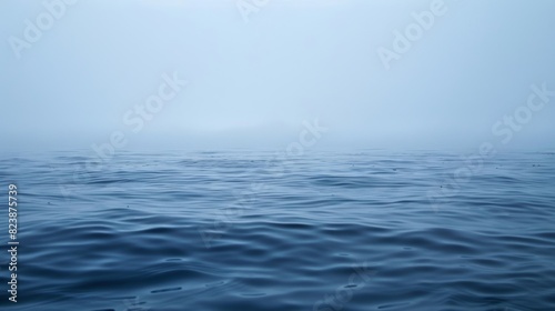 A misty ghostlike haze rises from the ocean surface making it difficult to see the horizon. photo
