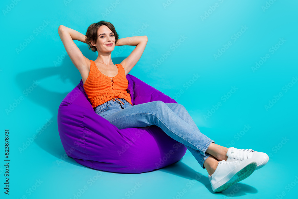 Φωτογραφία Full size photo of satisfied gorgeous girl wear orange knit top sit on bean bag