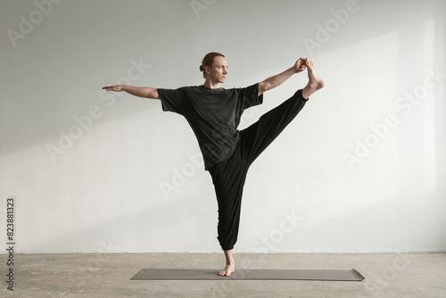 Man standing in Revolved Standing Hand to Big Toe pose photo