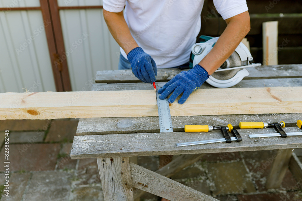 a man processes wood in the yard a man processes wood in the yard