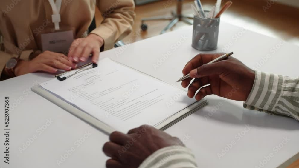 Cropped shot of unrecognizable manager and client signing service contract sitting at desk in bank office