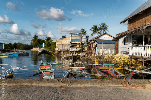 Traditional boats and stilt houses at tropical shoreline photo